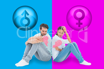 Composite image of sad couple sitting holding two halves of brok