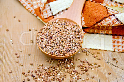 Buckwheat in spoon and napkin on board