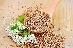 Buckwheat in spoon on board with flower