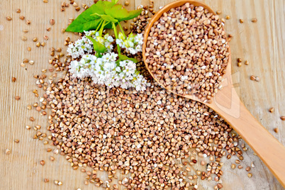 Buckwheat on board with flower and spoon