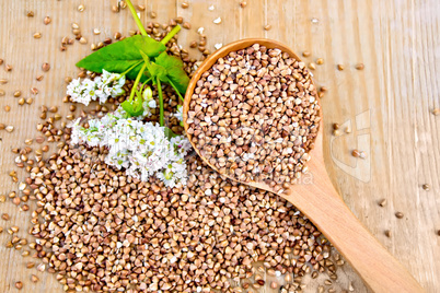 Buckwheat on board with flower and wooden spoon