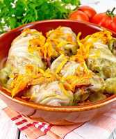 Cabbage stuffed and carrots in ceramic pan on board