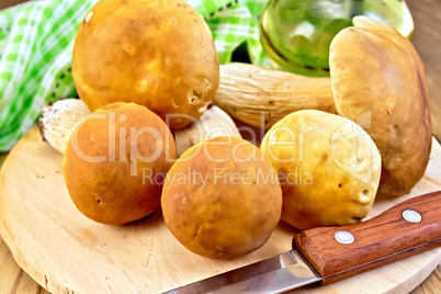 Ceps with knife and napkin on board