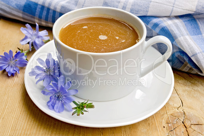 Chicory drink in white cup with napkin on board