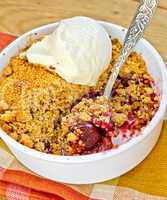 Crumble cherry in bowl with ice cream on napkin