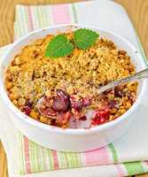 Crumble cherry in bowl with spoon on napkin