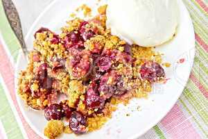 Crumble cherry in plate with spoon on tablecloth