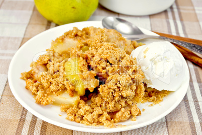 Crumble with pears in plate on tablecloth
