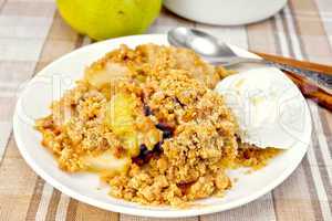 Crumble with pears in plate on tablecloth