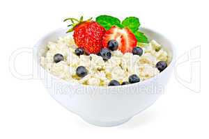 Curd in bowl with strawberries and blueberries
