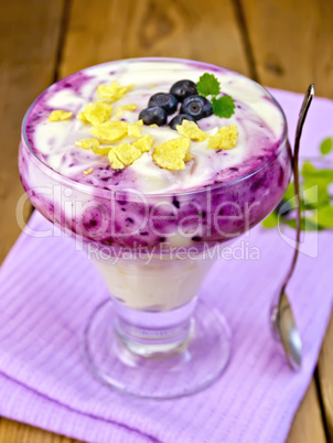 Dessert milk with blueberries on purple napkin