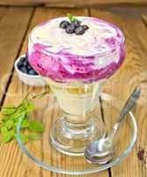 Dessert milk with blueberries in glassware on board