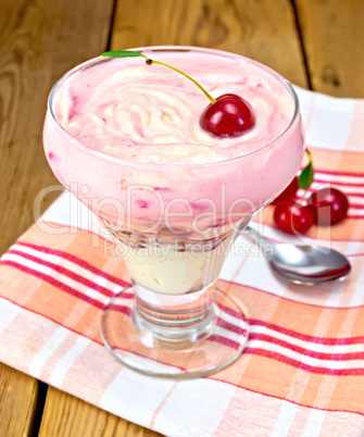 Dessert milk with cherry and spoon on board