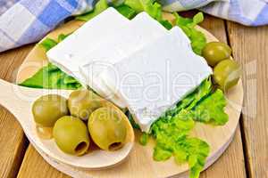 Feta with olives and lettuce on board and spoon