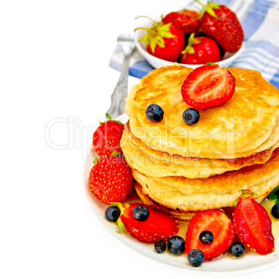 Flapjacks with strawberries and blueberries in bowl with napkin