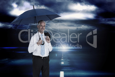 Composite image of happy businessman holding umbrella