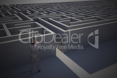 Composite image of thinking businessman holding pen