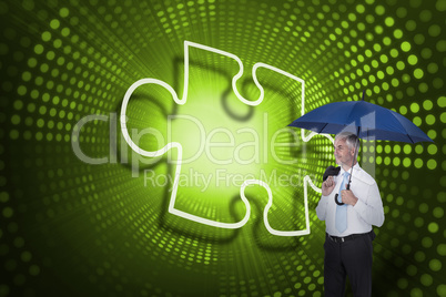 Composite image of jigsaw piece and businessman holding umbrella