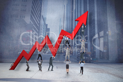 Composite image of business team holding up arrow