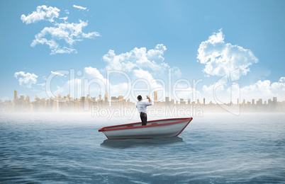 Composite image of businessman posing with arms up in a sailboat