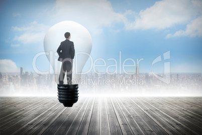 Composite image of thinking businessman in light bulb