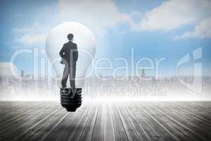 Composite image of thinking businessman in light bulb