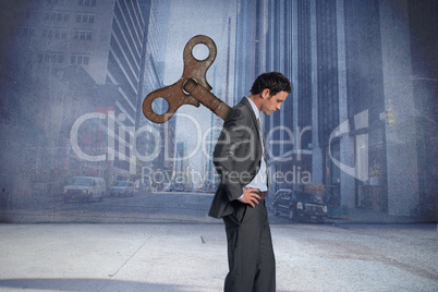 Composite image of wound up businessman with hands on hips