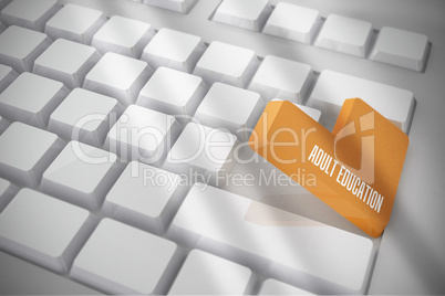 Adult education on white keyboard with orange key