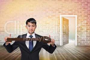 Composite image of unsmiling businessman carrying large key