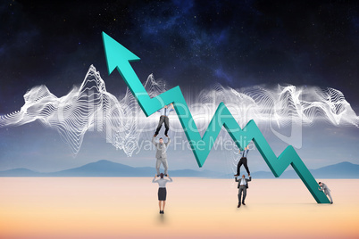 Composite image of business team holding up arrow