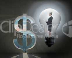 Composite image of businesswoman holding tablet in light bulb