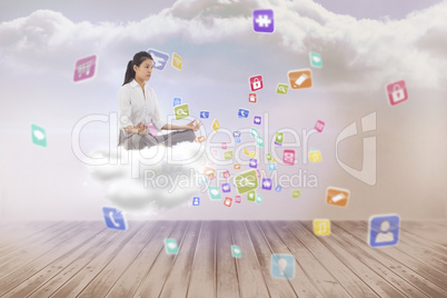 Composite image of businesswoman sitting in lotus pose