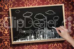 Composite image of hand drawing cityscape with chalk