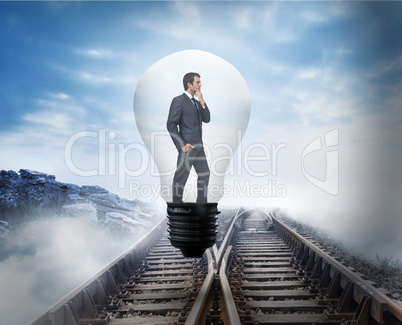 Composite image of thinking businessman in light bulb