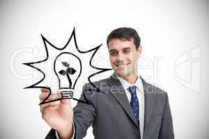 Composite image of businessman drawing light bulb