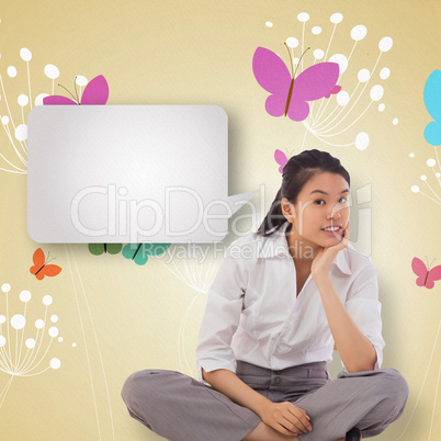 Composite image of businesswoman sitting cross legged thinking w