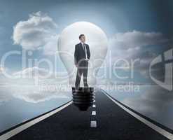 Composite image of thinking businessman in light bulb