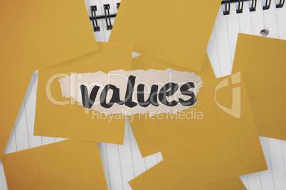 Values against yellow paper strewn over notepad
