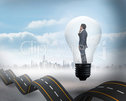 Composite image of thinking businessman in light bulb