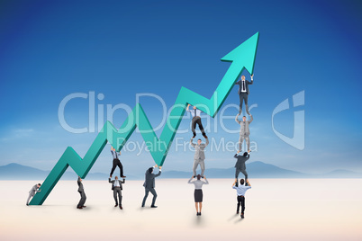 Composite image of business team holding up arrow