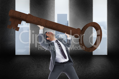 Composite image of unsmiling businessman carrying large key