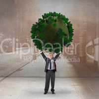 Composite image of businessman holding green sphere