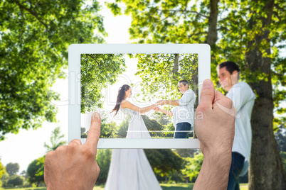 Composite image of hand holding tablet pc