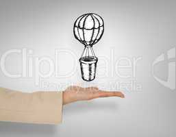 Composite image of female hand presenting hot air balloon