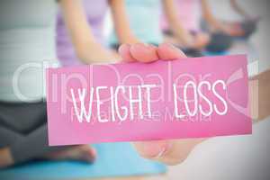 Woman holding pink card saying weight loss