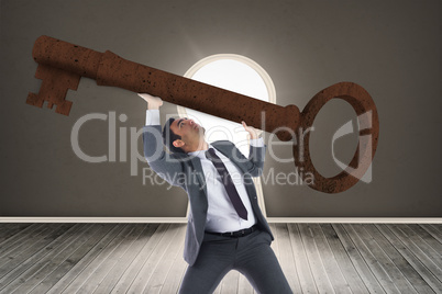 Composite image of unsmiling businessman carrying large key