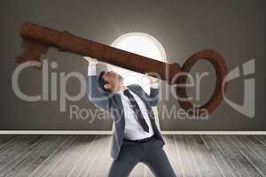 Composite image of unsmiling businessman carrying large key