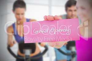 Fit blonde holding card saying grand opening