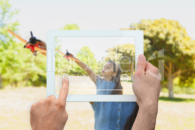 Composite image of hand holding tablet pc