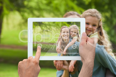 Composite image of hand holding tablet pc